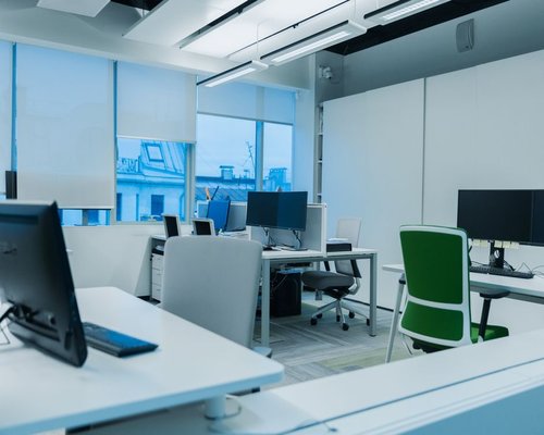 A modern well-lit office workspace in Monterrey featuring clean desk setups and ergonomic screen heights